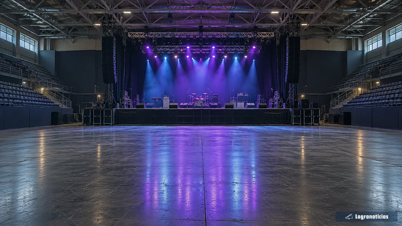 Pabellón vacío con escenario iluminado antes de un concierto