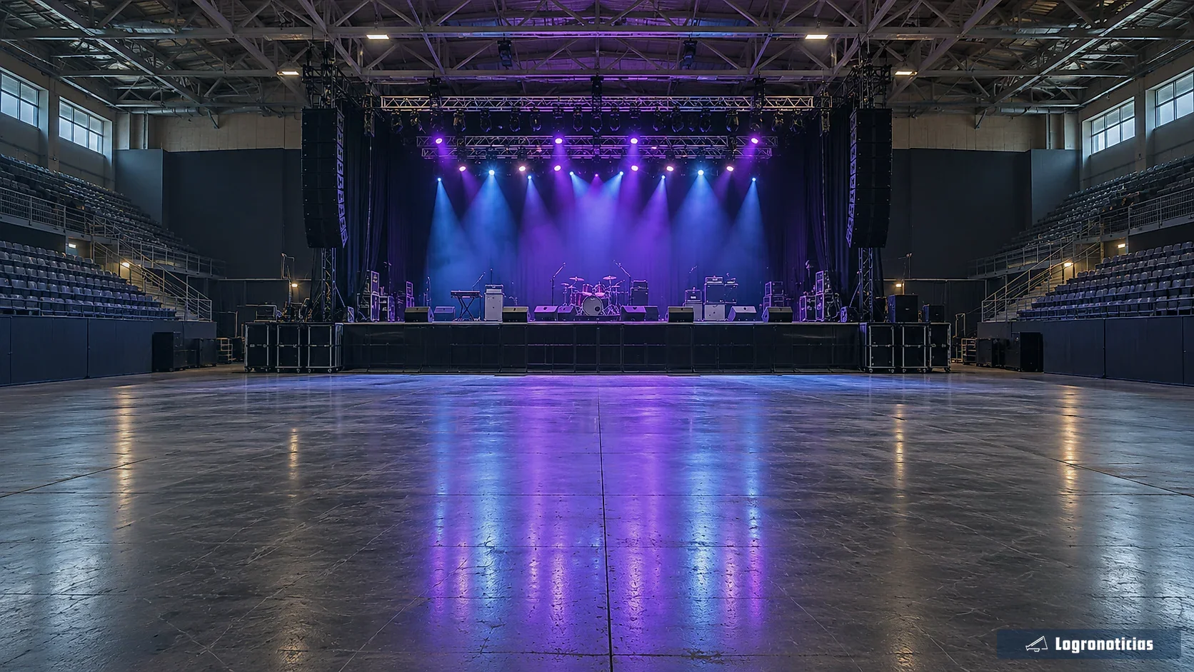 Pabellón vacío con escenario iluminado antes de un concierto