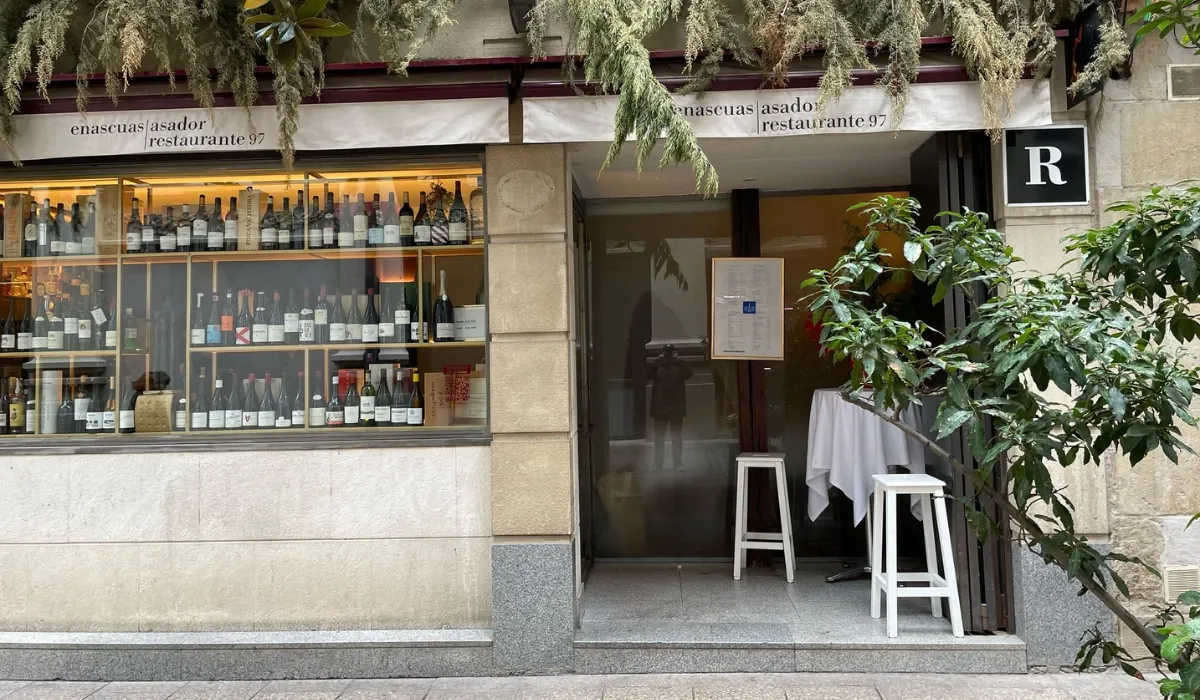 Fachada de Enascuas 97 con escaparate lleno de botellas de vino