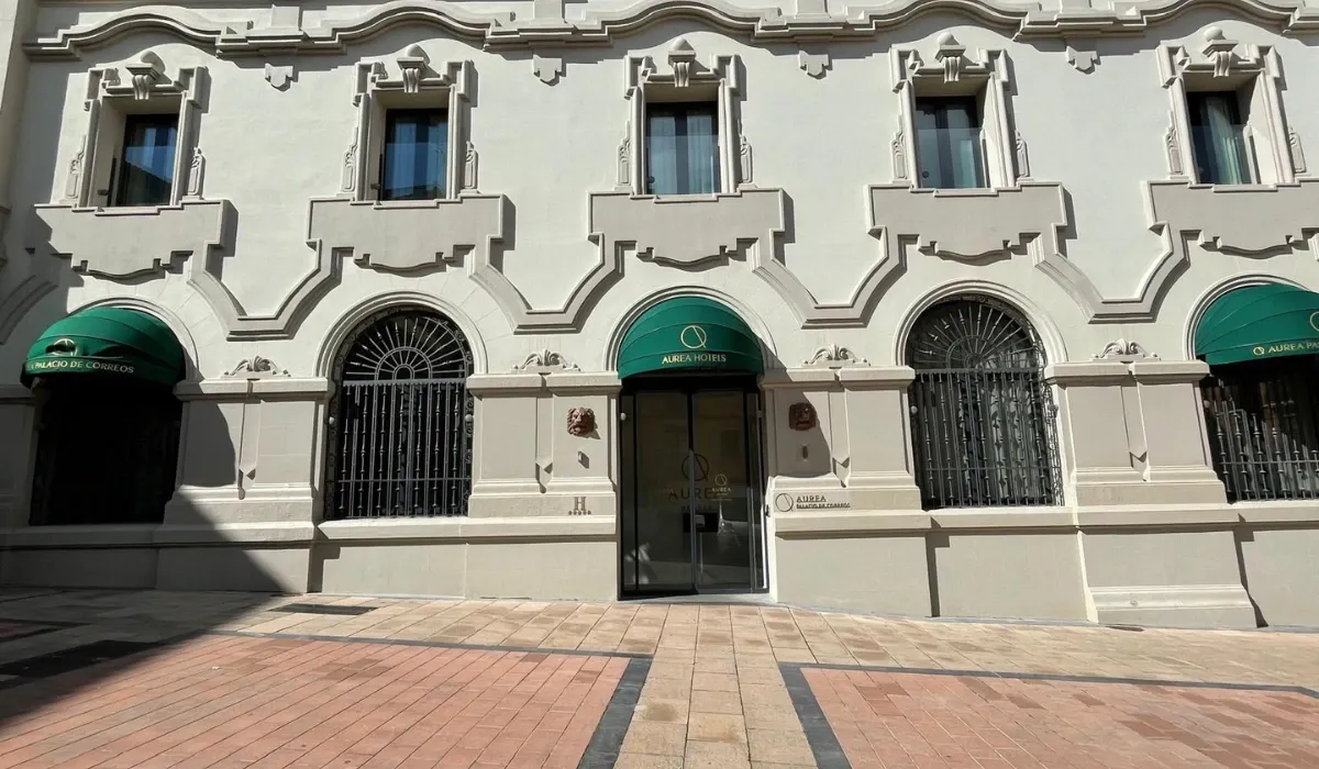 Fachada del hotel Áurea Palacio de Correos con toldos verdes y rejas