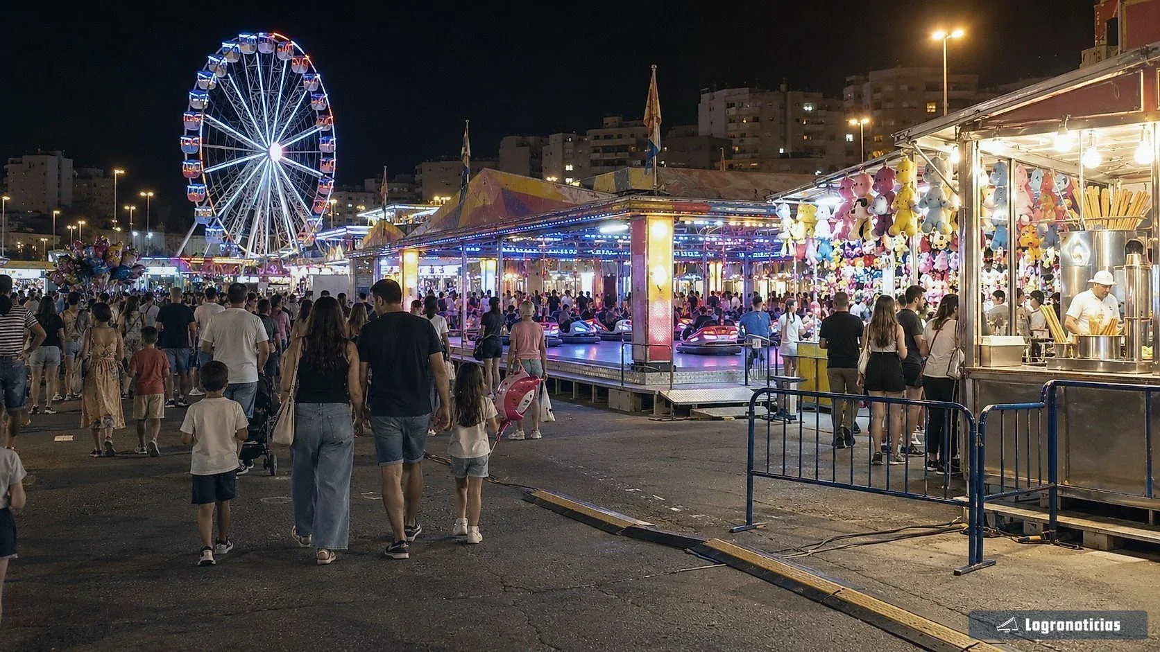 Noria y puestos de feria iluminados con gente paseando de noche