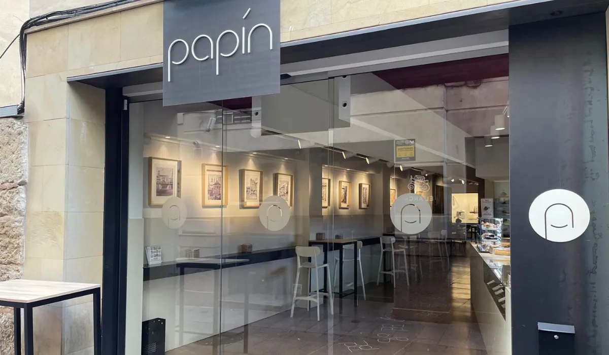 Escaparate de la pastelería Papín con láminas enmarcadas en la pared interior