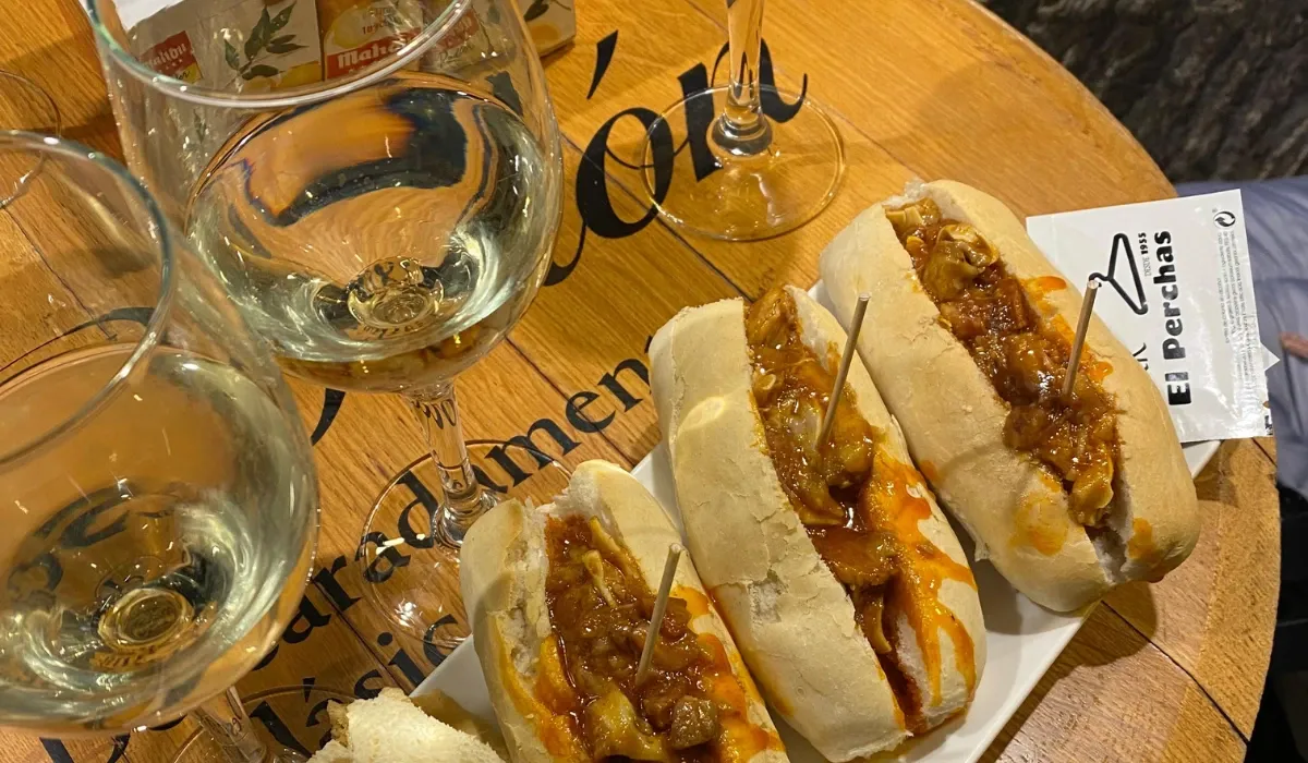 Bocatitas de oreja sobre la barra de El Perchas, con copas de vino