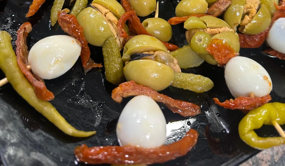 Banderillas de aceituna, guindilla, huevo de codorniz y pepinillo en una bandeja