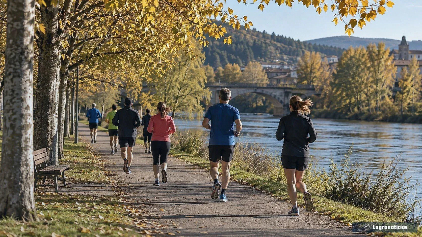 Corredores populares en un camino junto al río en otoño
