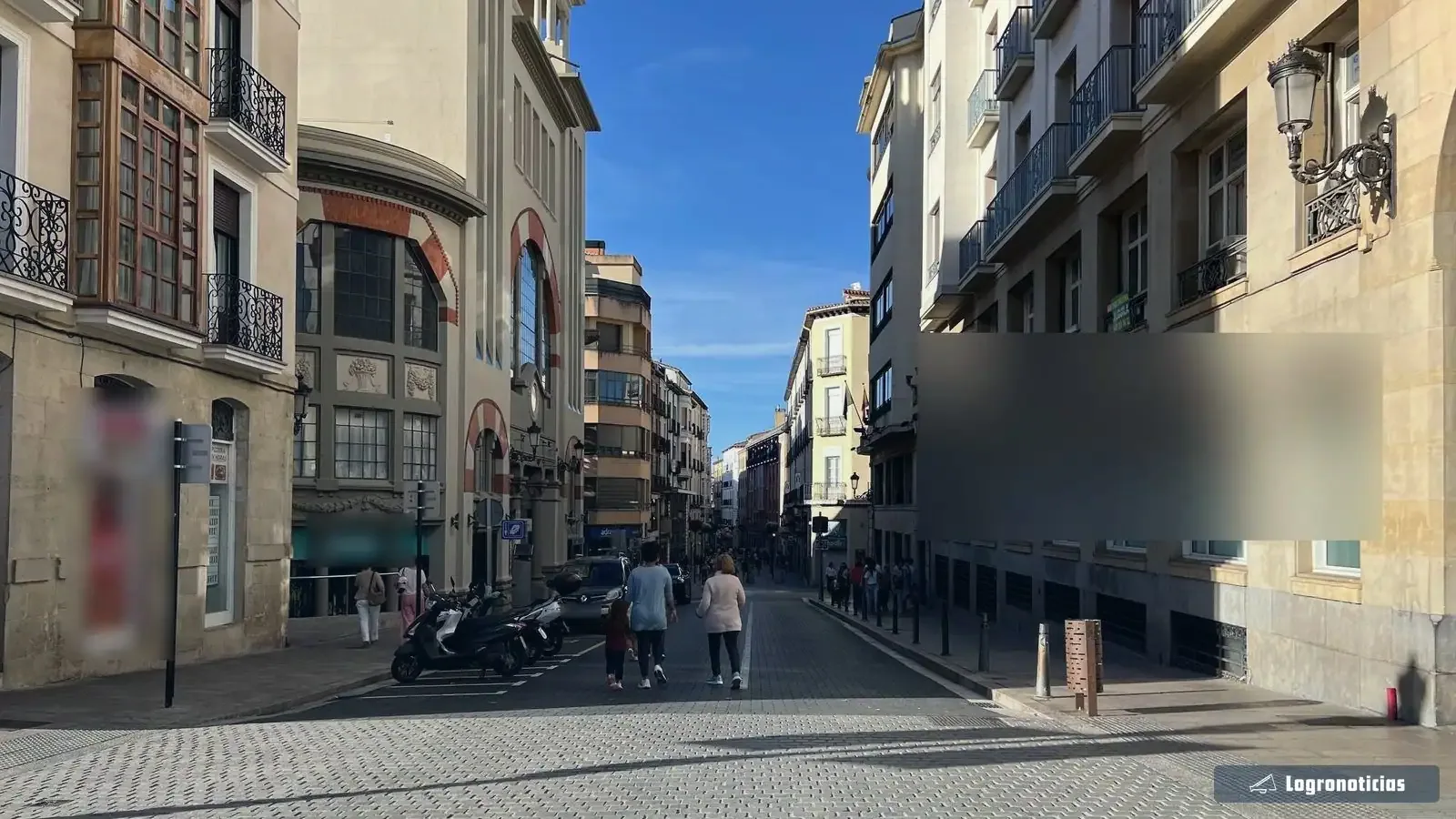 Calle del centro de Logroño con paseantes y motos aparcadas a media tarde