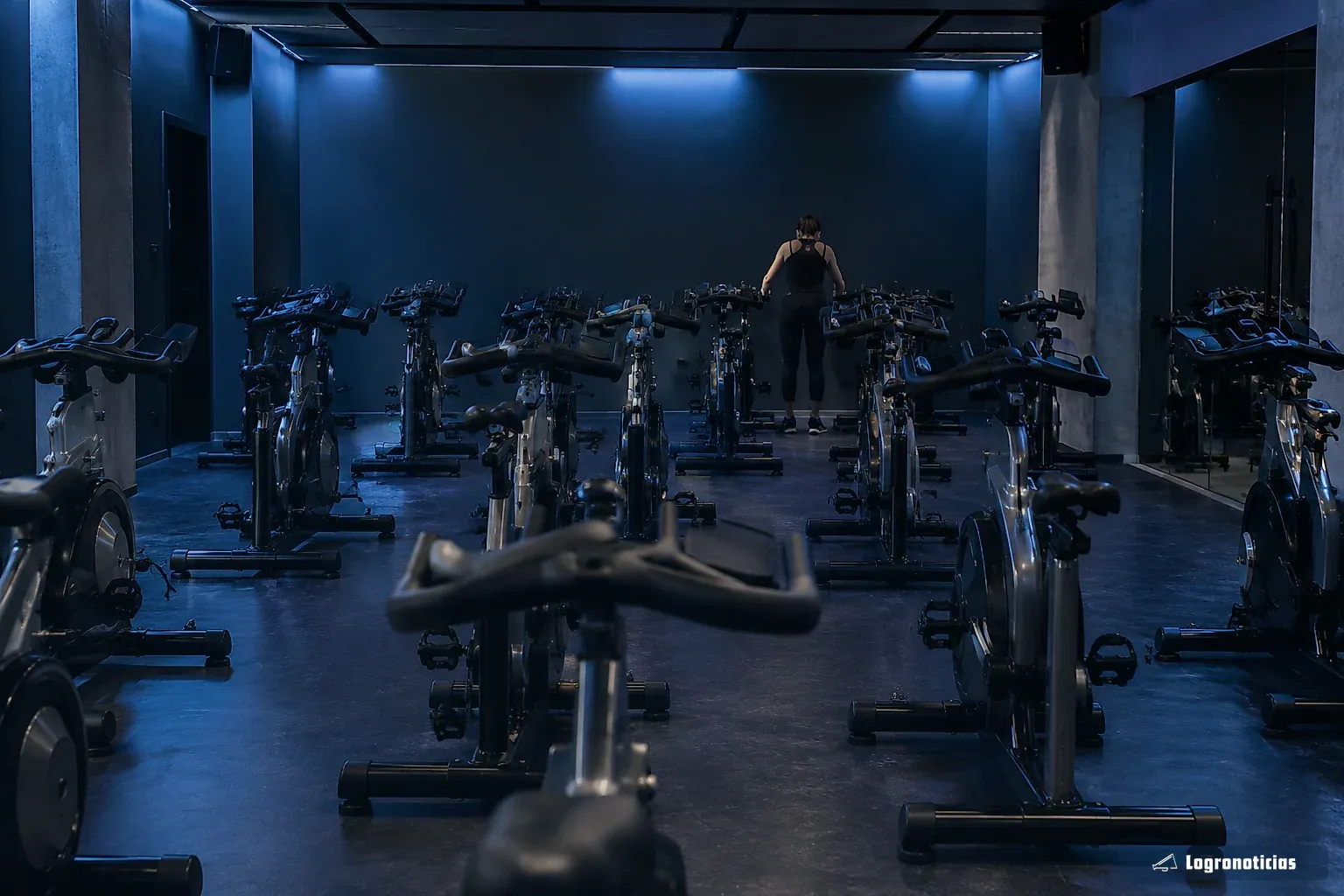 Bicicletas de ciclo indoor alineadas en una sala con luz tenue