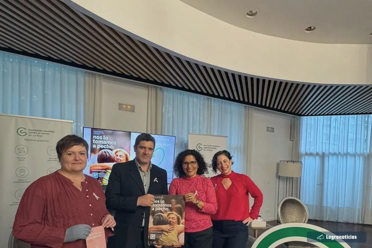 Participantes del desayuno informativo con el cartel de la campaña «Nos lo tomamos a pecho»