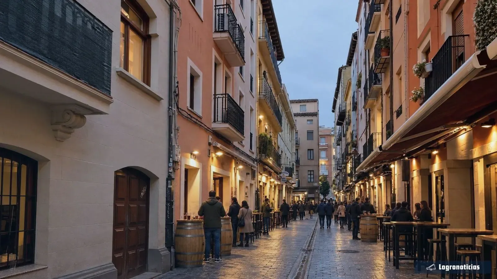 Calle peatonal del casco antiguo al atardecer, con barricas en la puerta de los bares