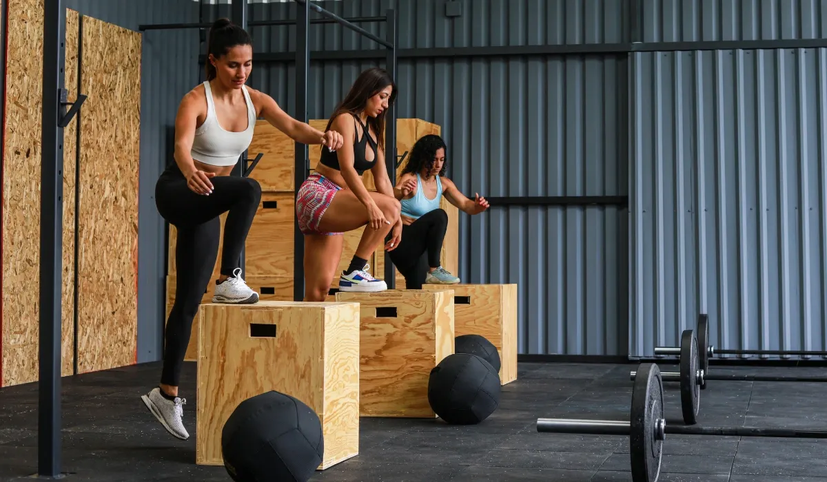 Tres mujeres suben a cajones de madera durante un entrenamiento