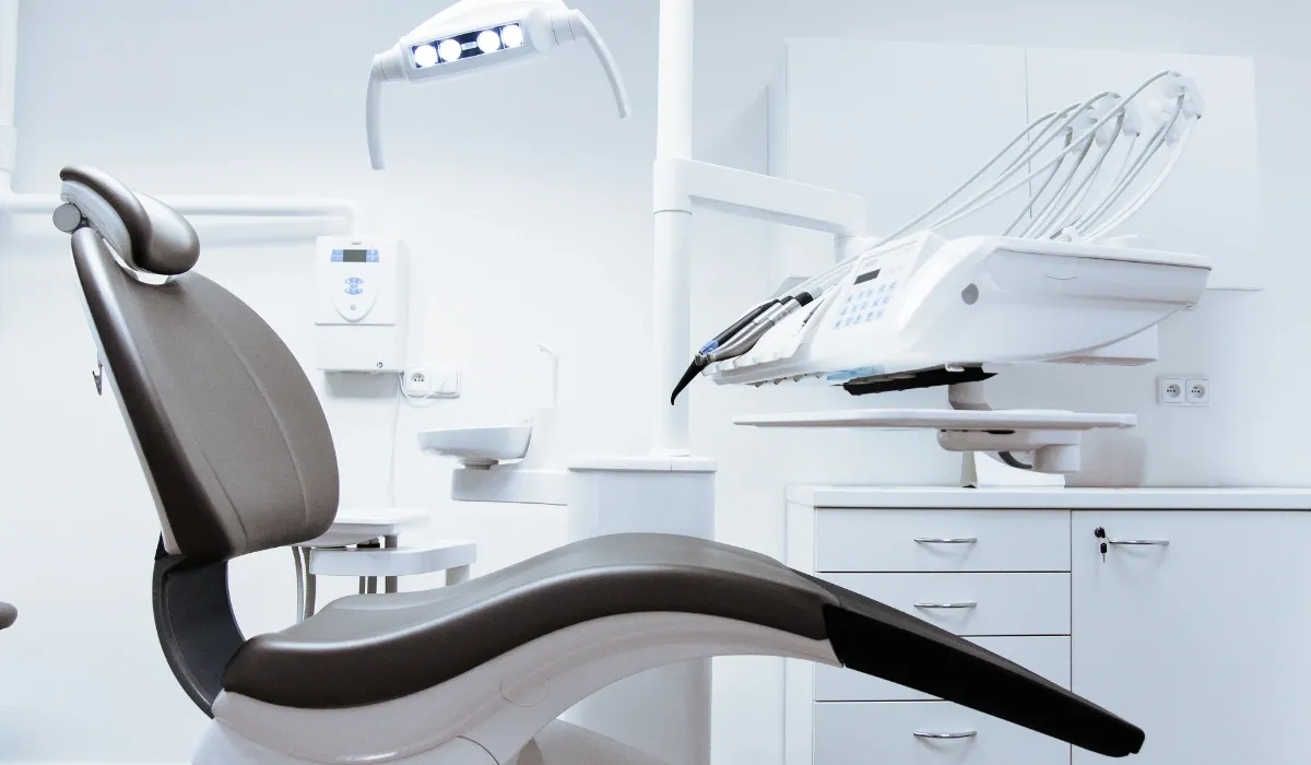 Sillón dental vacío con lámpara y equipo en una consulta blanca