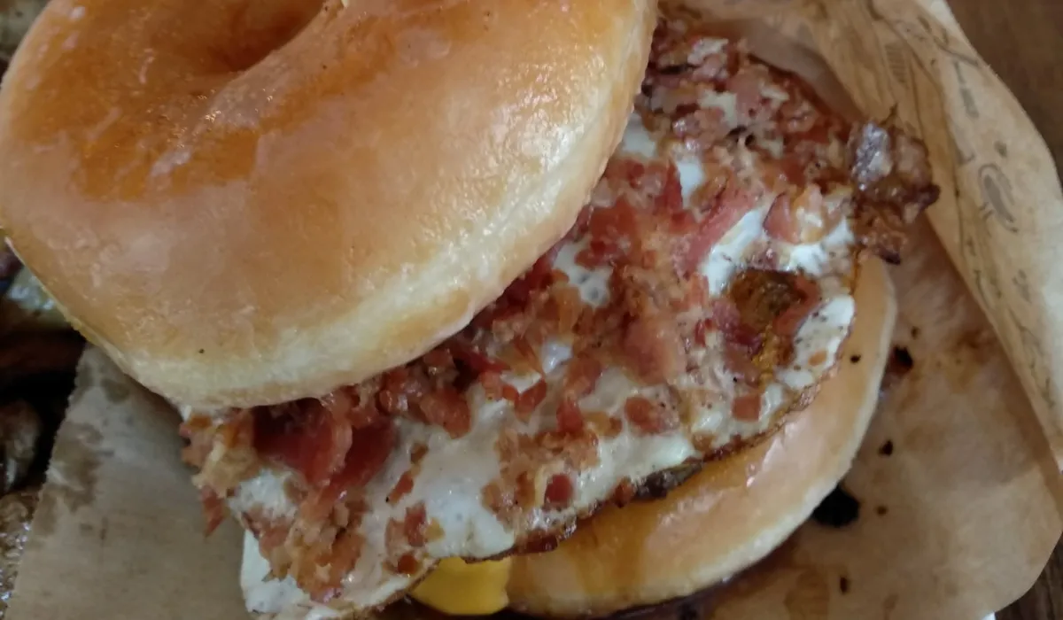 Hamburguesa con pan de donut glaseado, huevo a la plancha y beicon