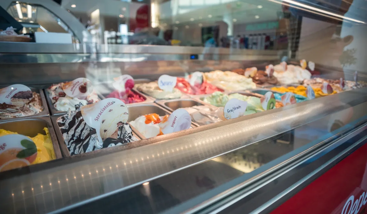 Vitrina de heladería con cubetas de helado de varios sabores