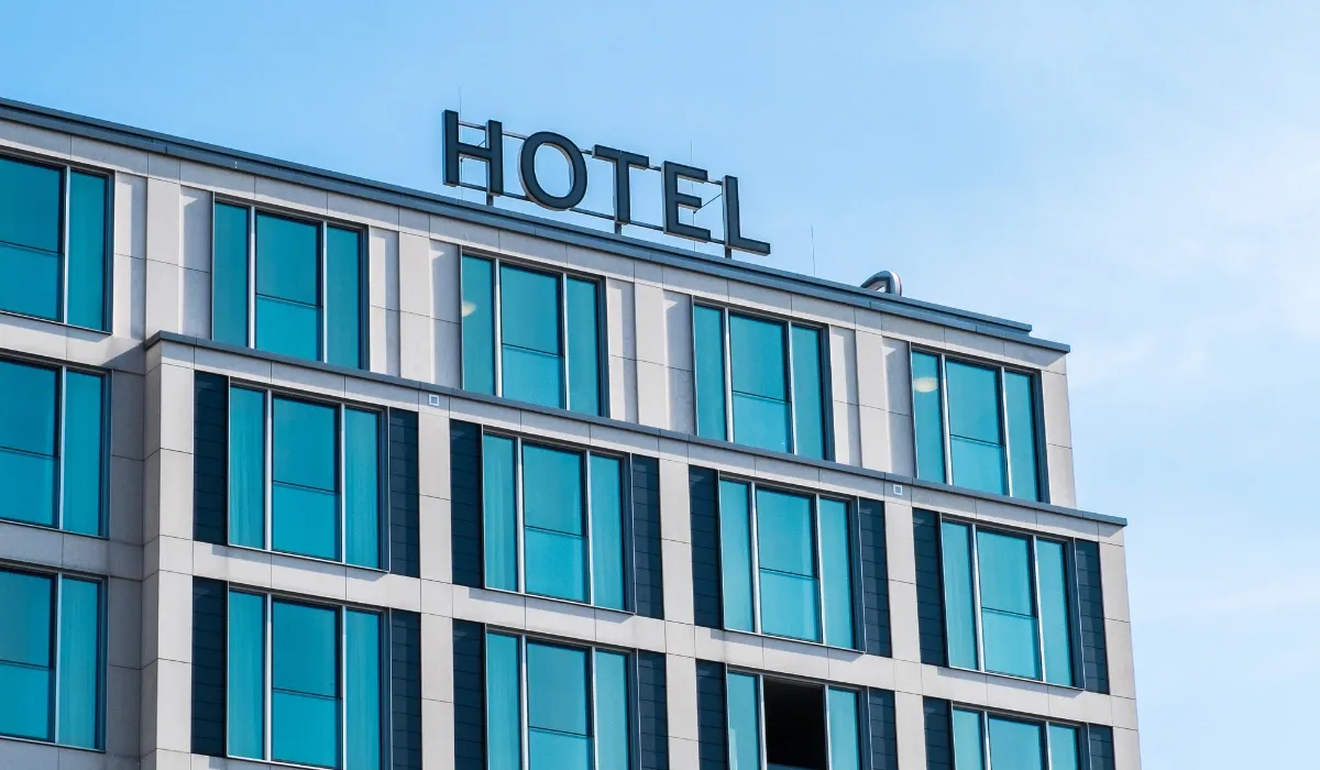 Fachada de un hotel moderno con ventanales y rótulo en la azotea