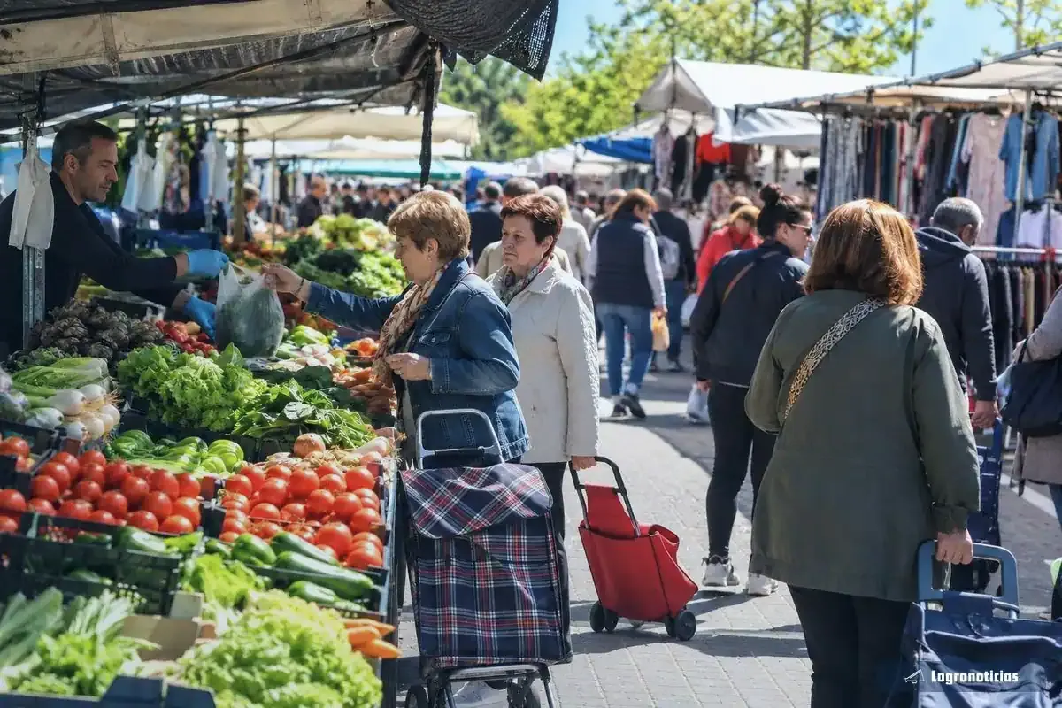 Puestos de verdura y ropa en un mercadillo al aire libre