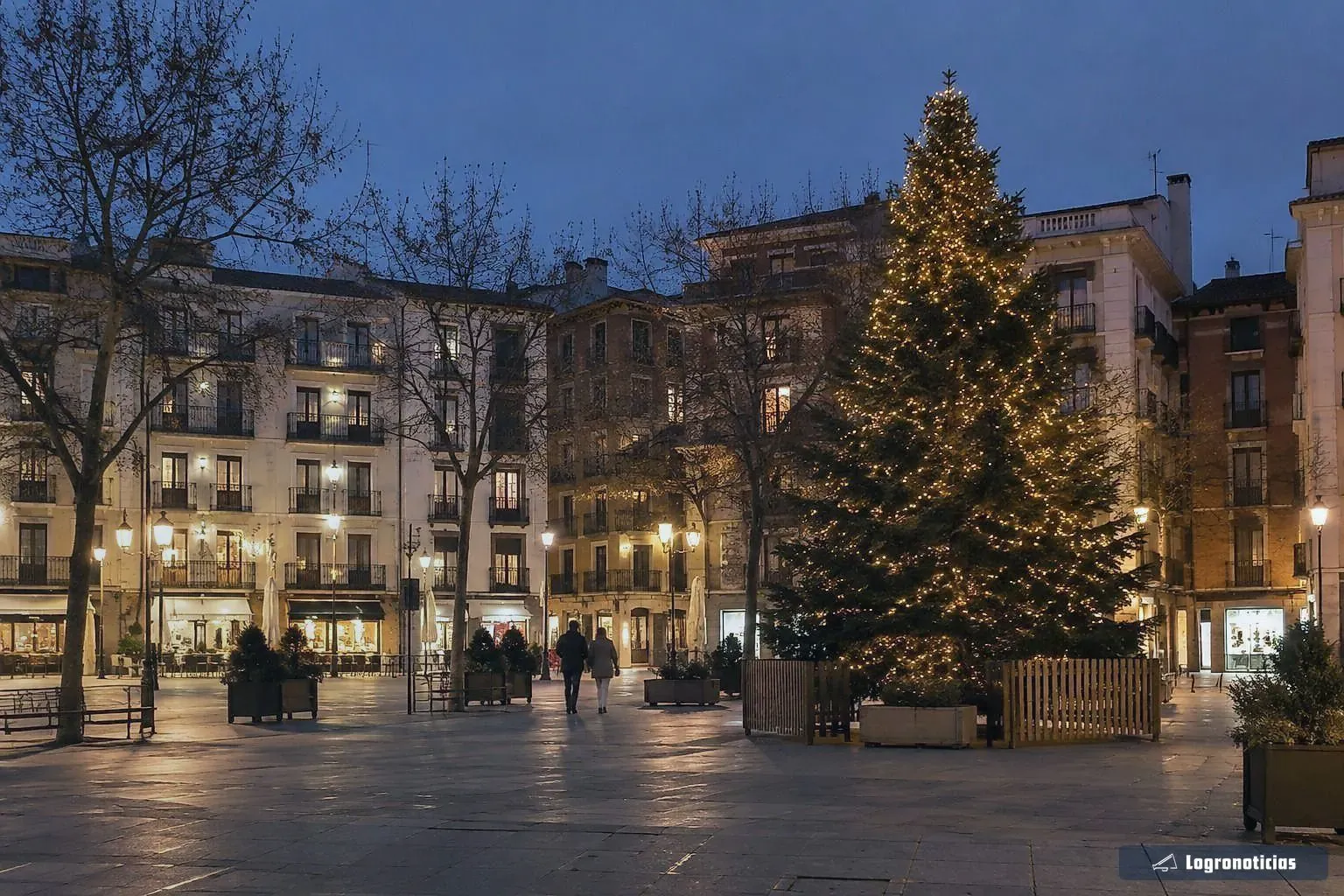 Gran árbol de Navidad iluminado en una plaza al anochecer