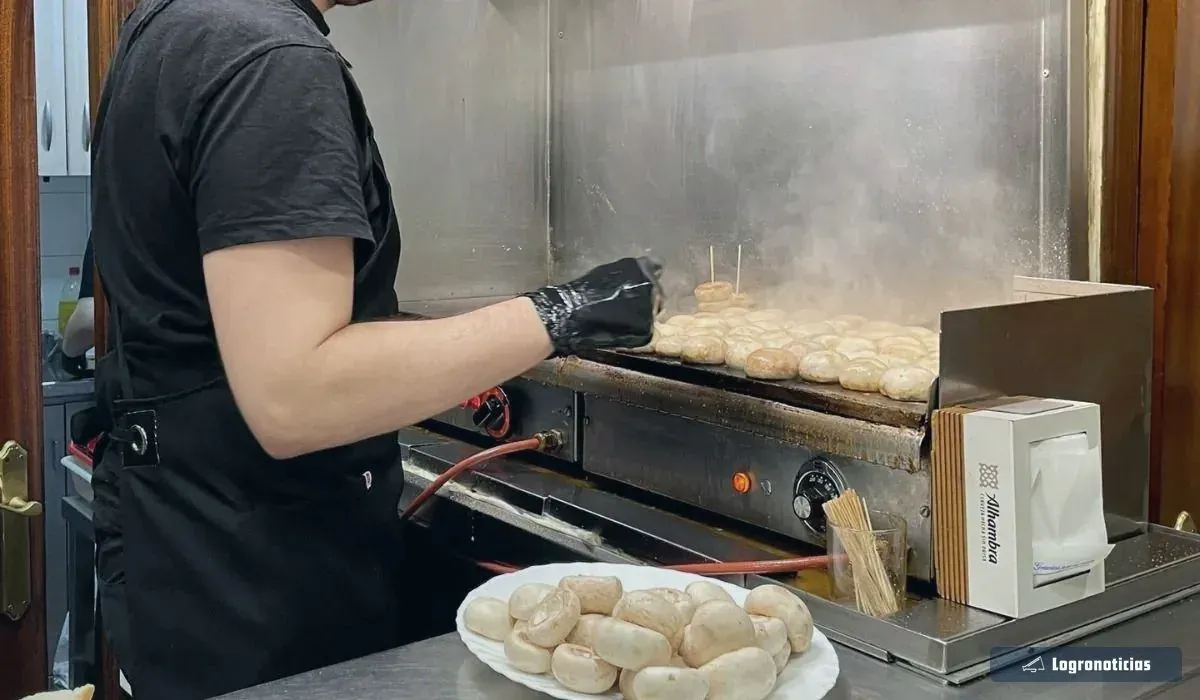 Champiñones haciéndose en la plancha de un bar de pinchos