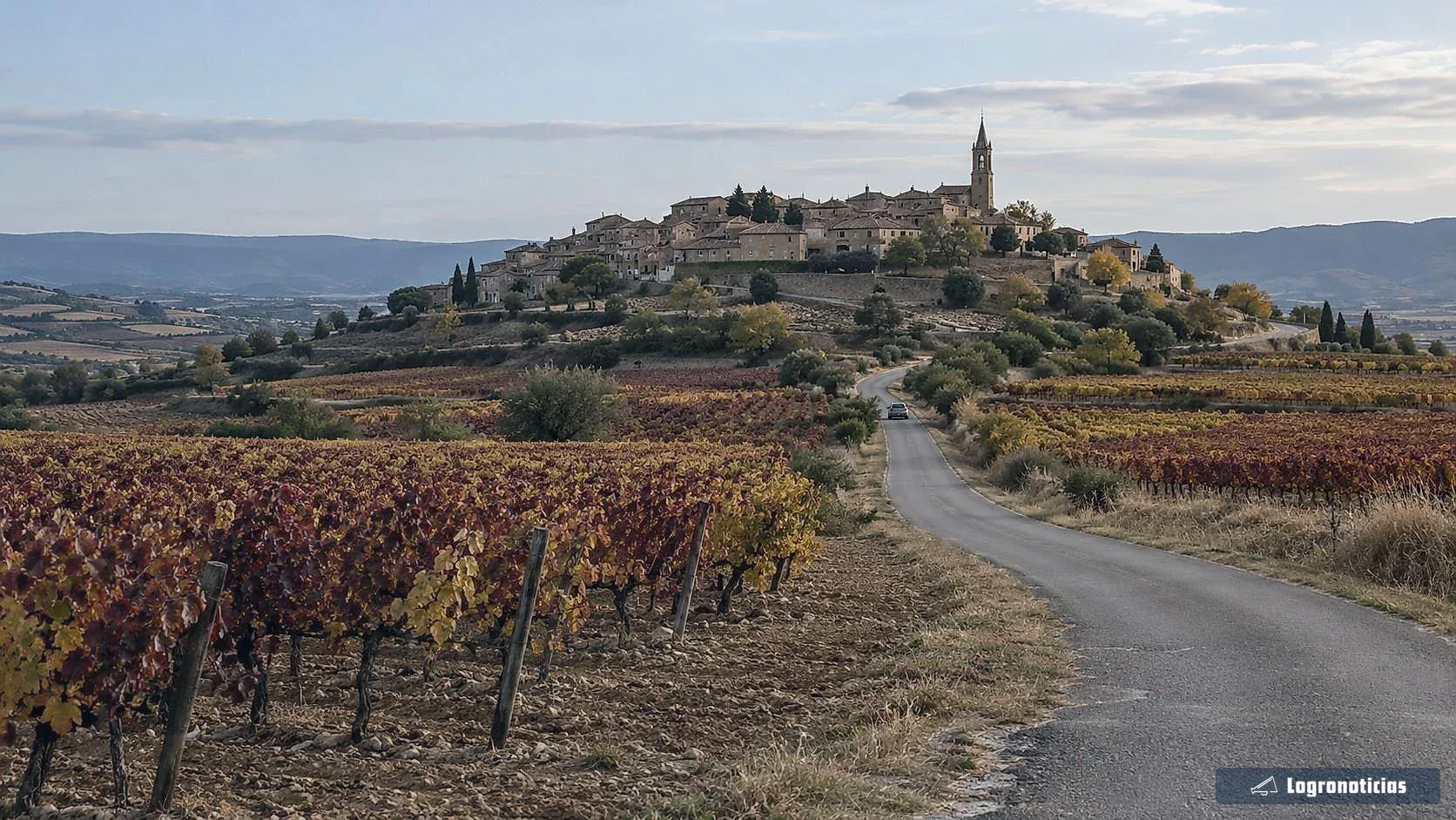 Pueblo de piedra en lo alto de un cerro rodeado de viñedos de otoño