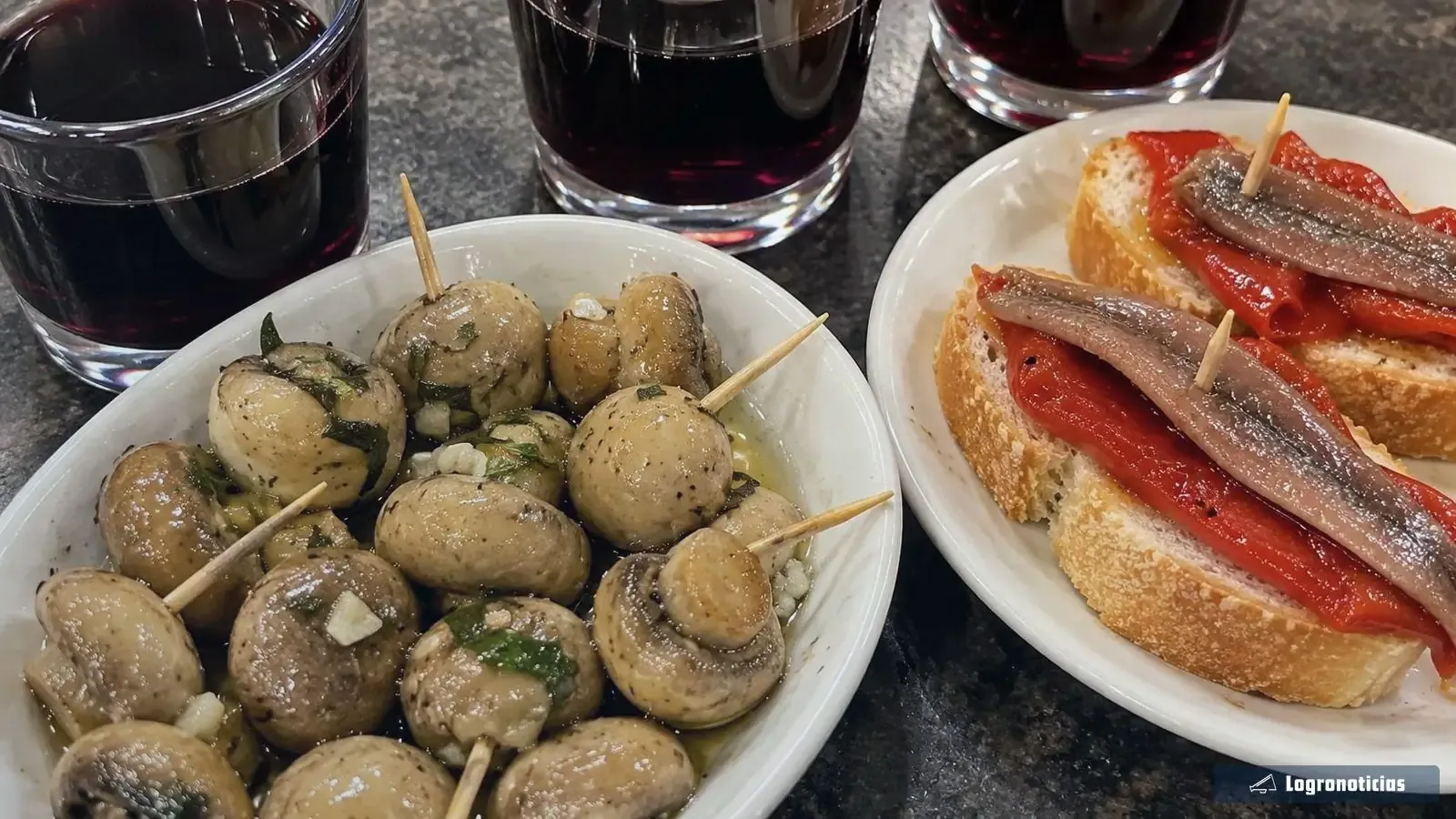 Vino tinto con champiñones y pan con anchoa y pimiento