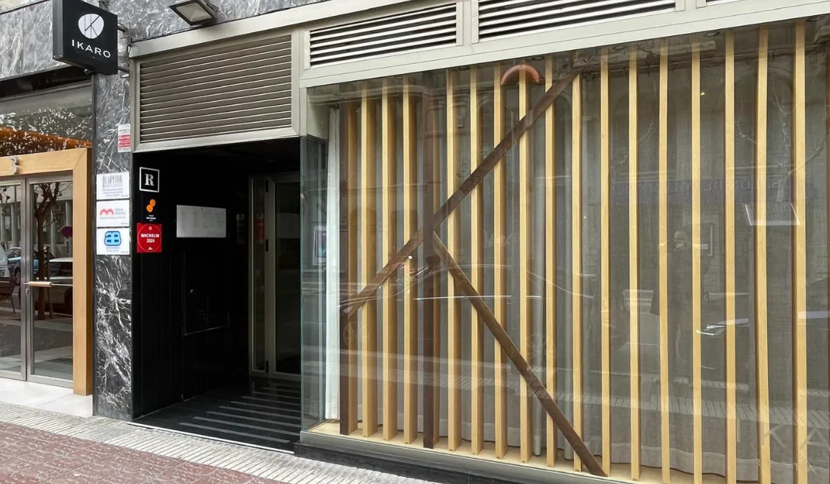 Fachada del restaurante Ikaro con celosía de listones de madera tras el cristal