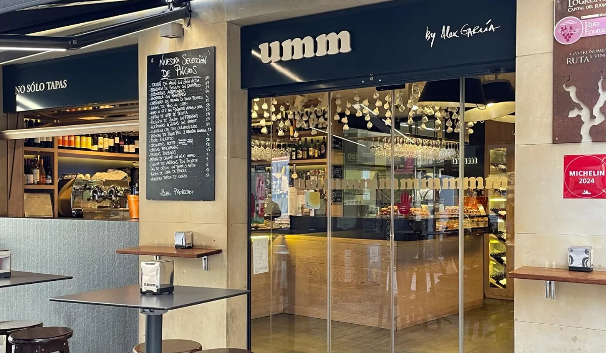 Entrada acristalada de UMM No Solo Tapas con pizarra de pinchos y barra al fondo