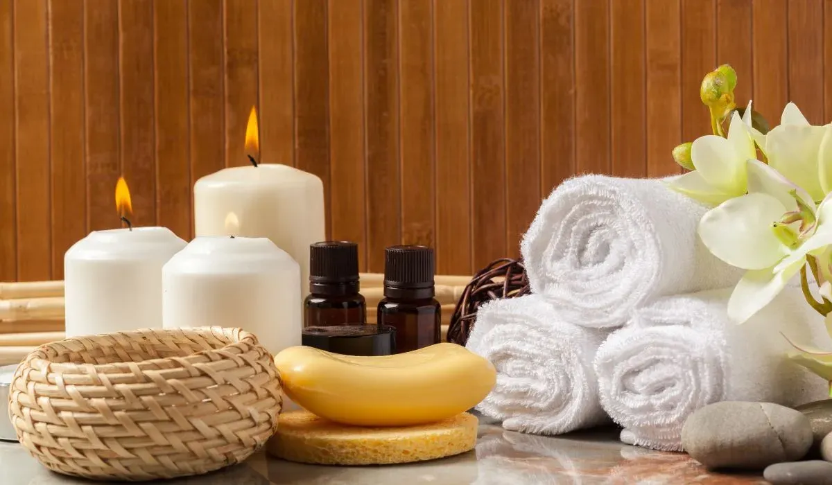 Velas, toallas blancas enrolladas y frascos de aceite en un spa