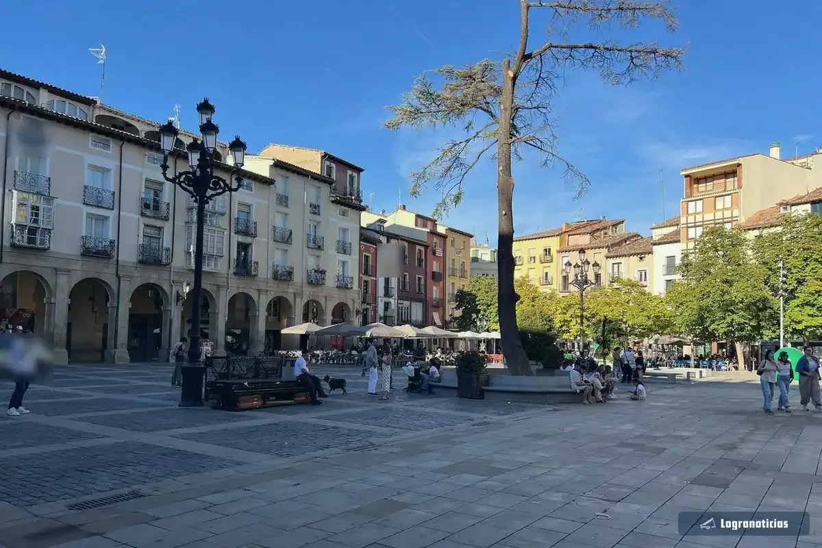 Soportales y terrazas con sombrillas al fondo de la plaza del Mercado de Logroño