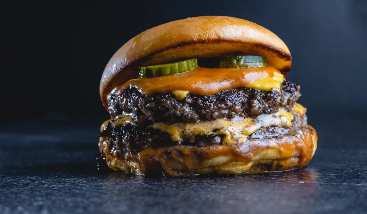 Smash burger doble con queso fundido, pepinillo y pan brioche tostado