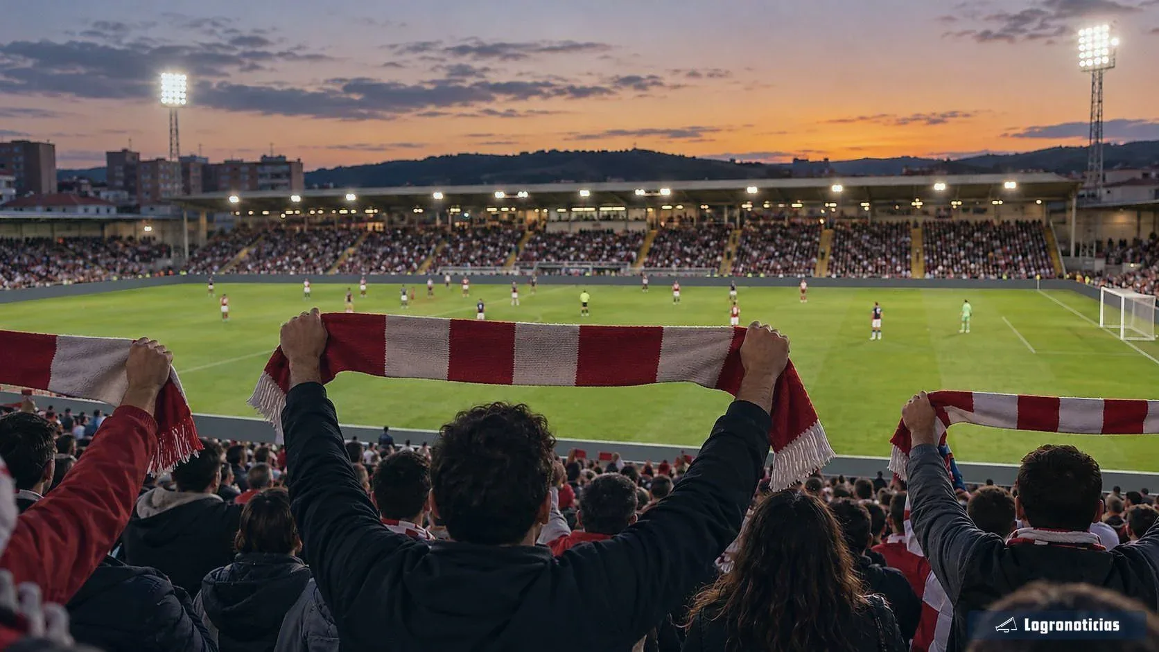 Aficionados con bufandas rojas y blancas en la grada de un estadio al atardecer