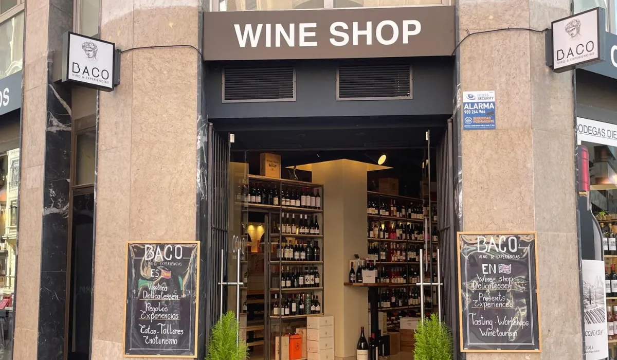 Entrada de la vinoteca Baco con estanterías de botellas y pizarras